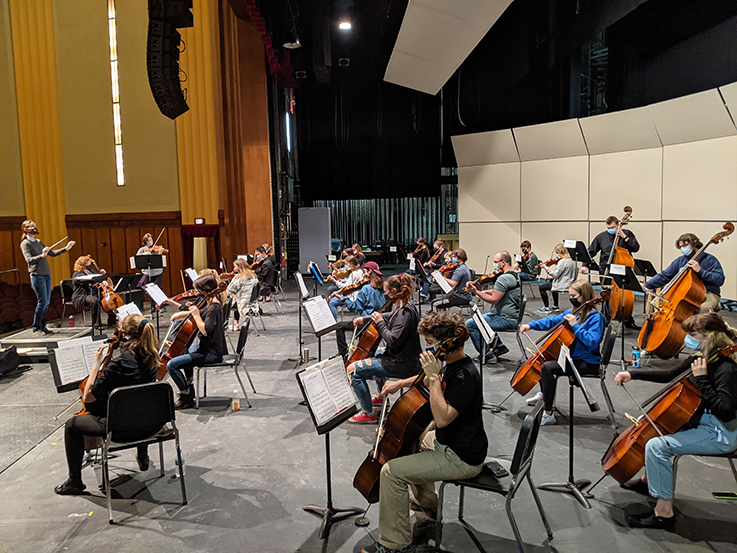 High school orchestra playing on stage during the festival
