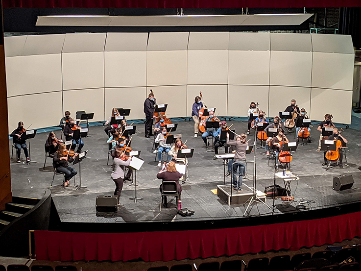 High school orchestra playing on stage during the festival