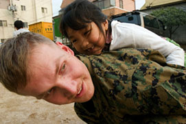 Lance Cpl. Godwin Olivier with Son Jin, a child of the Ja Won Social Welfare Corporation, during a community relations project in Korea. (Photo by UNC CFC USFK, www.flickr.com/photos/unc-cfc-usfk)
