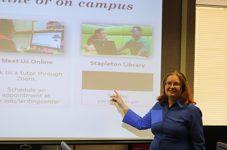Professor Dana Driscoll pointing at a slide presentation