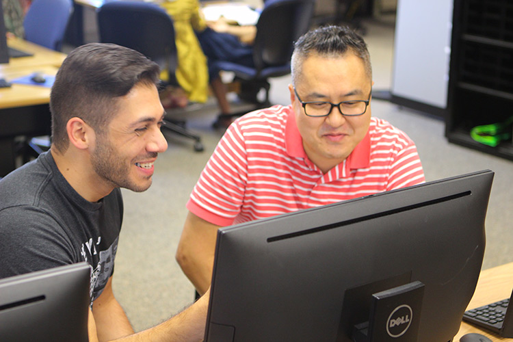 Student and tutor working at a computer.