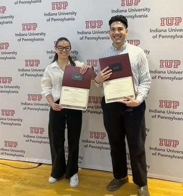 two tudents standing with their awards 