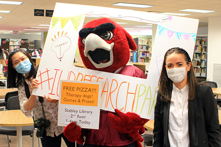 Two students with Norm the mascot